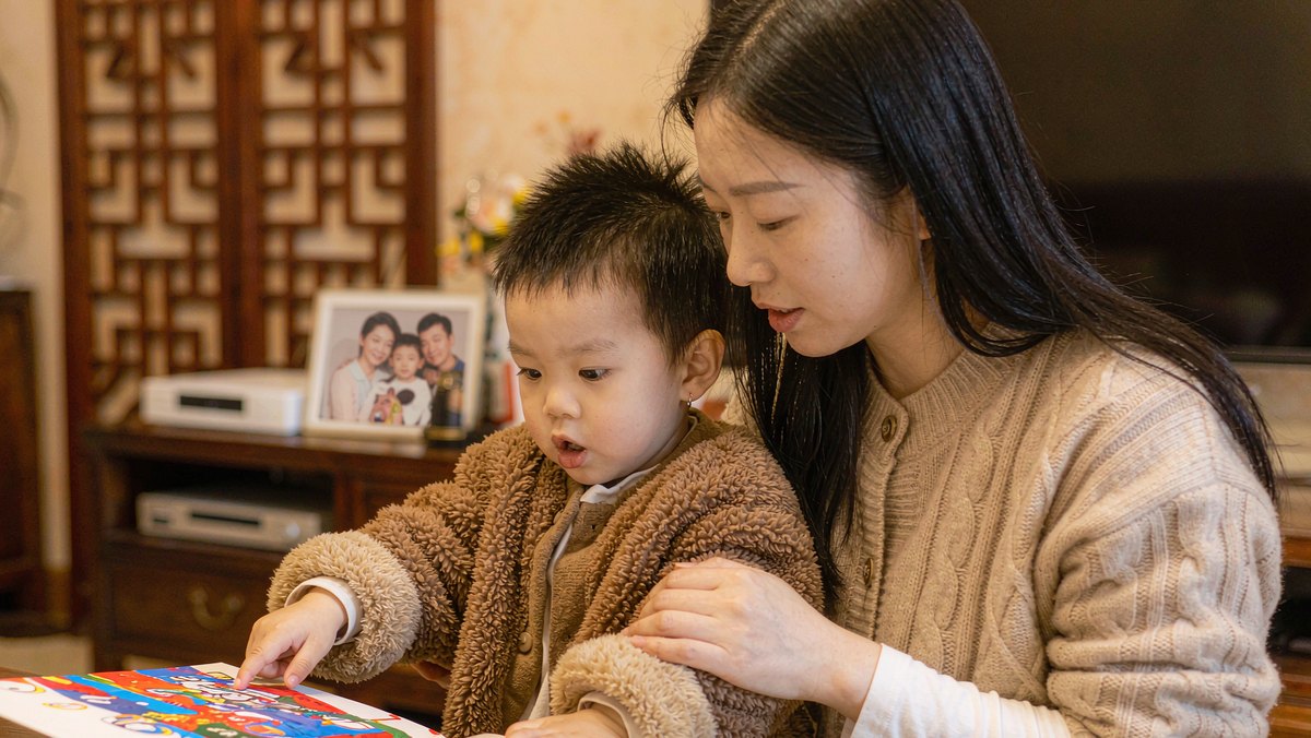 孩子指着绘本画面跟妈妈聊感受