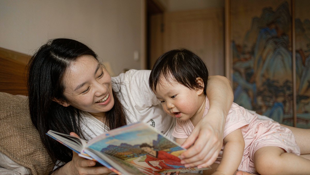 妈妈和孩子并排躺着聊绘本里的问题