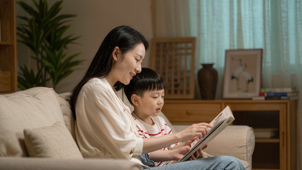 妈妈单独陪着大孩子读绘本,宝宝在爸爸怀里