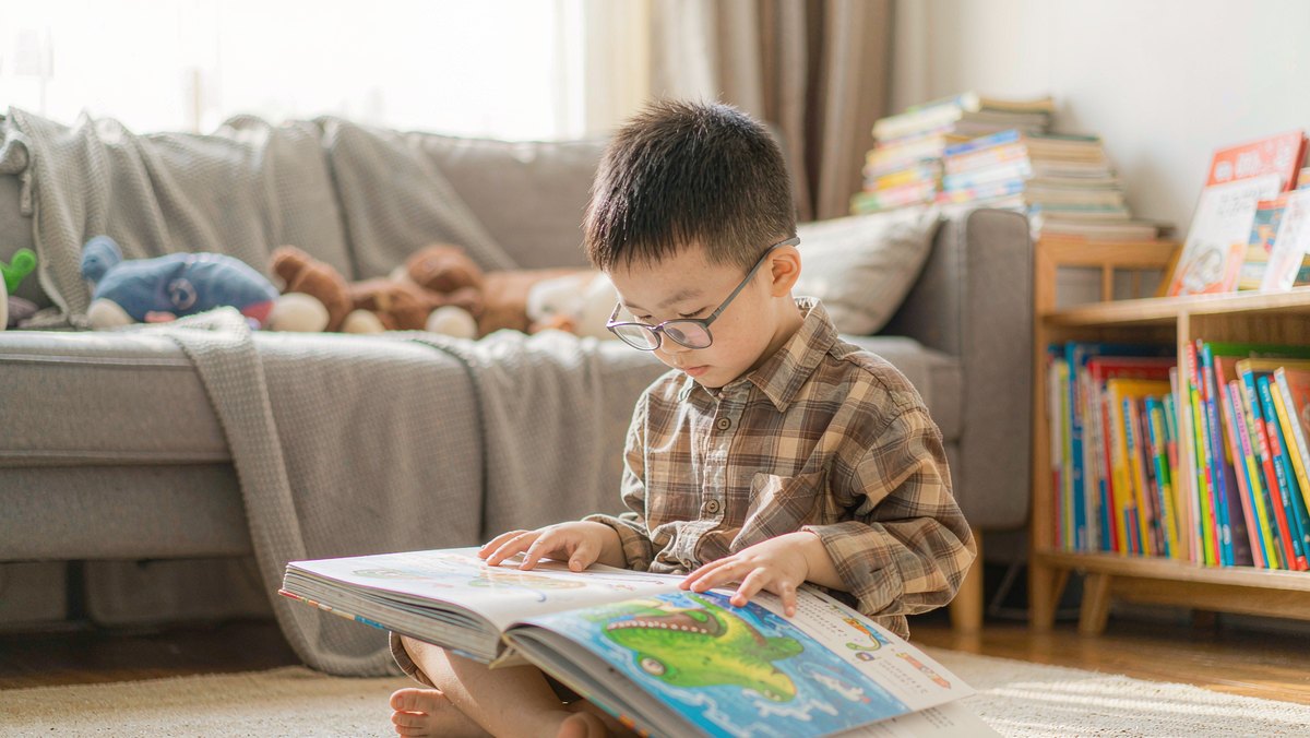 孩子抱着一本恐龙绘本认真翻看