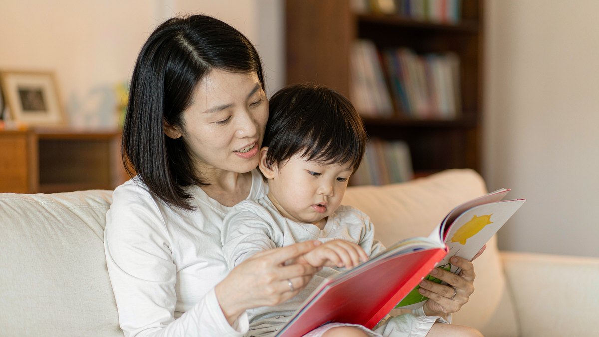 妈妈抱着孩子读绘本,孩子安静地听着