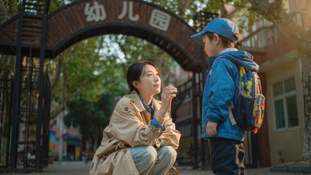 妈妈在幼儿园门口蹲下来和孩子说再见