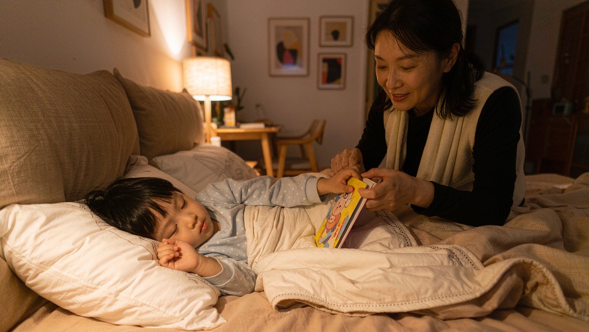 孩子抱着绘本睡着了,妈妈轻轻把书合上