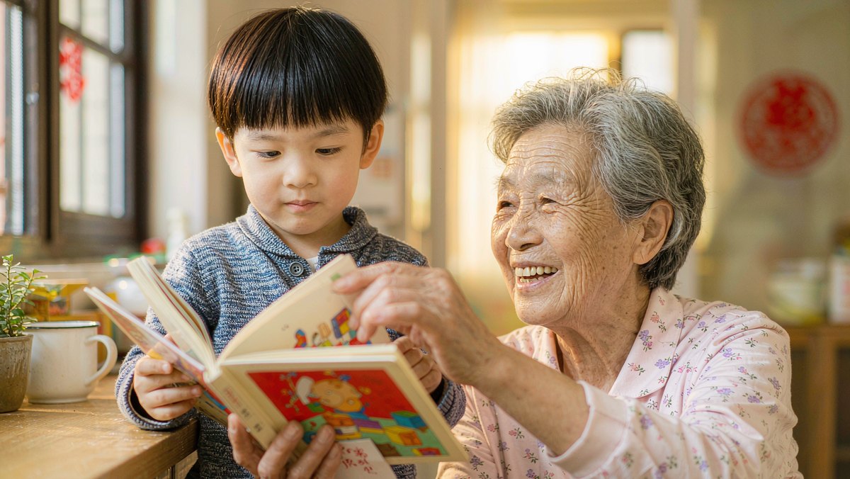 孩子把绘本递到奶奶手里,奶奶笑着接过来