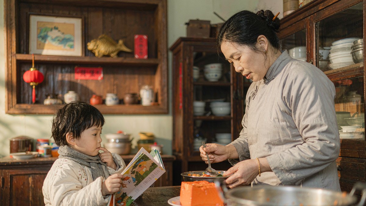 孩子抱着绘本站在妈妈身边等着一起读