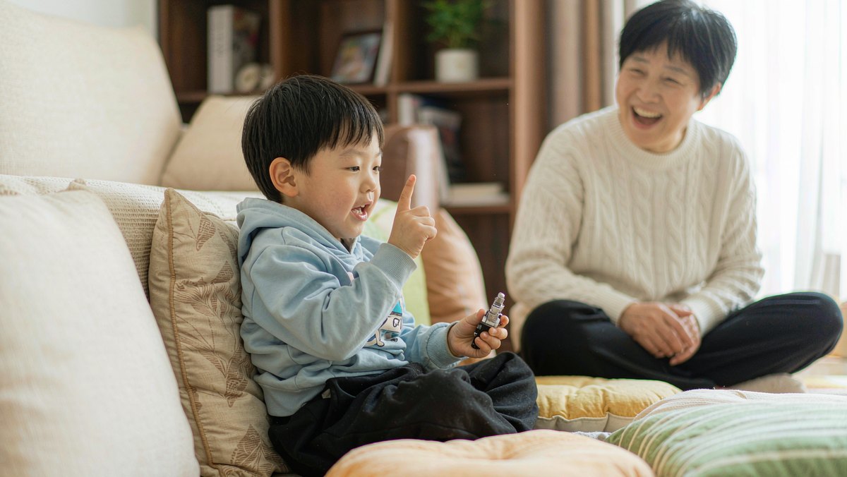 孩子把抱枕当道具在客厅表演绘本故事