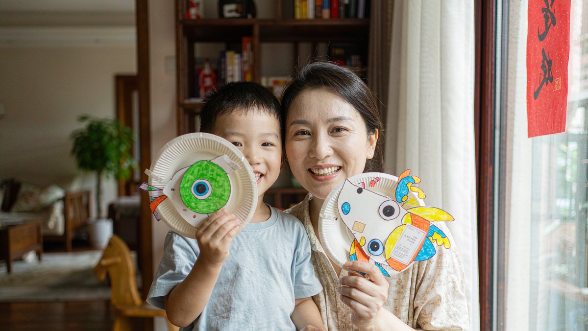 妈妈和孩子用纸盘动物一起表演绘本情节