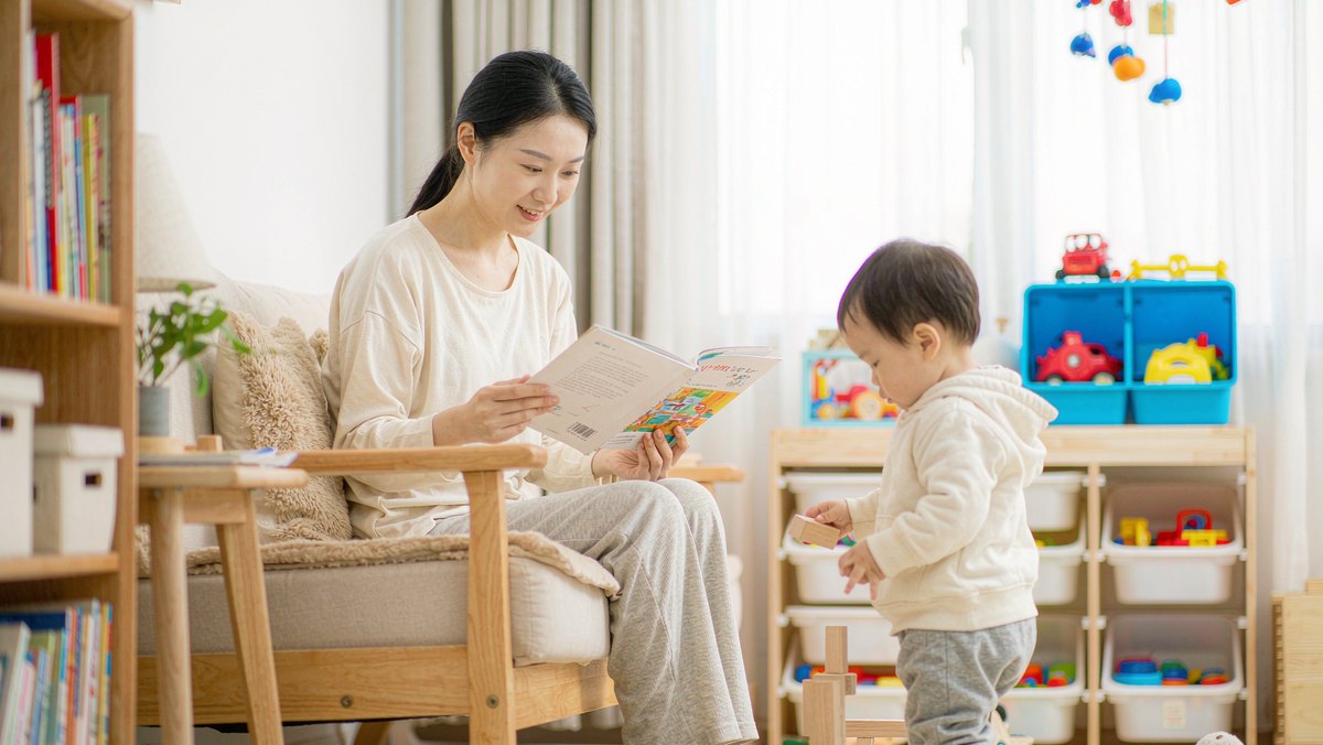 妈妈读绘本时孩子跑到旁边玩积木