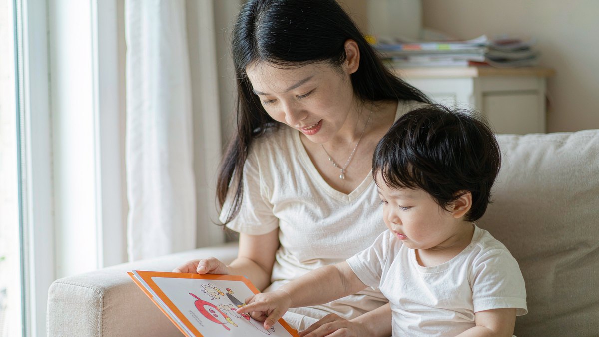 妈妈陪孩子一起翻看绘本的温馨瞬间