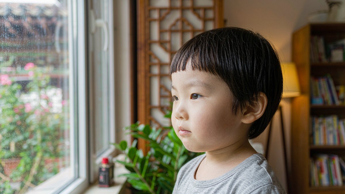 孩子若有所思望向窗外的安静时刻