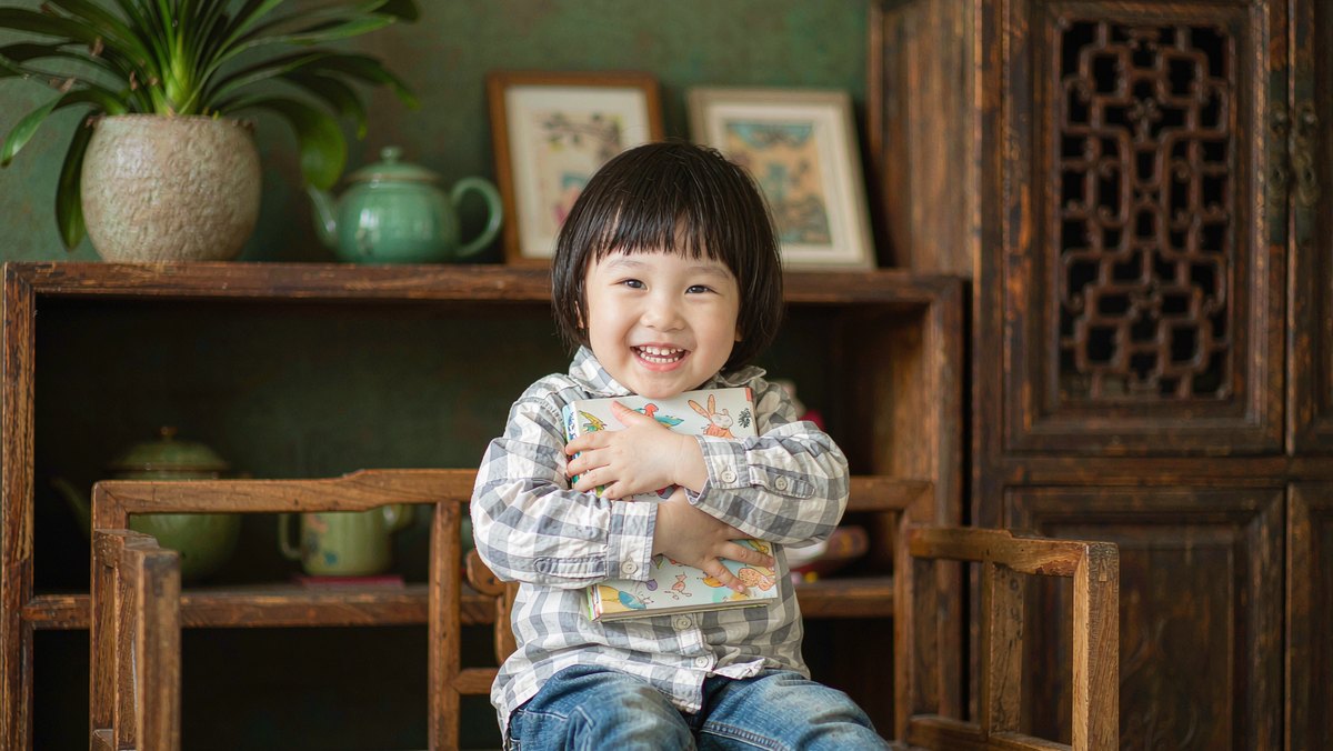 孩子抱着自己最爱的绘本开心地笑