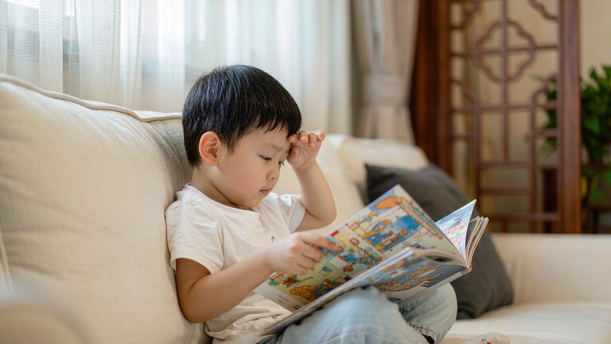 孩子专注地翻看一本全是图画的无字书