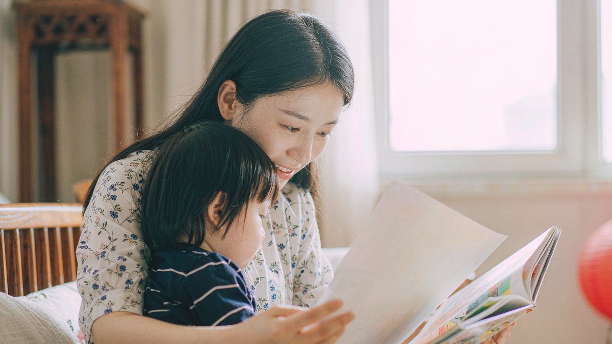 妈妈和孩子依偎着共读一本绘本