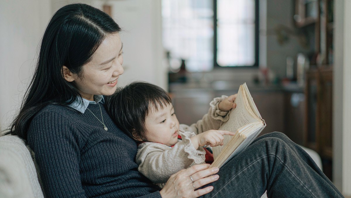 妈妈抱着孩子一起翻书