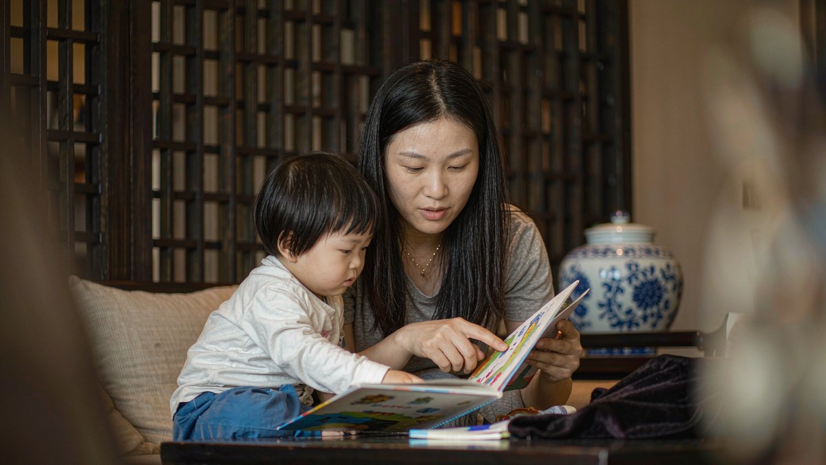 妈妈陪孩子在桌前翻书