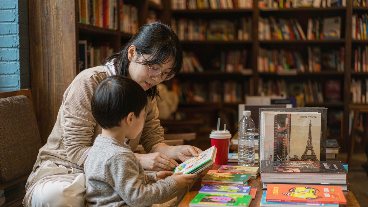 妈妈陪孩子在书店地上席地而坐翻书