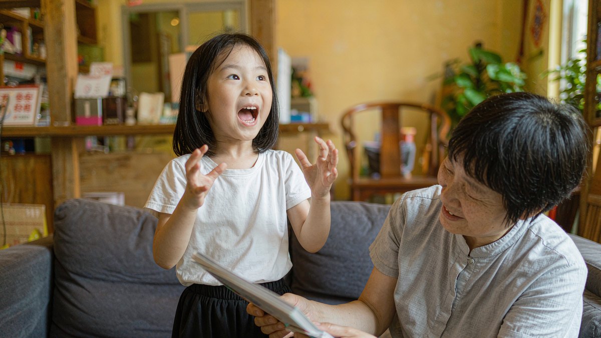 孩子眉飞色舞地给家长讲无字书里的故事