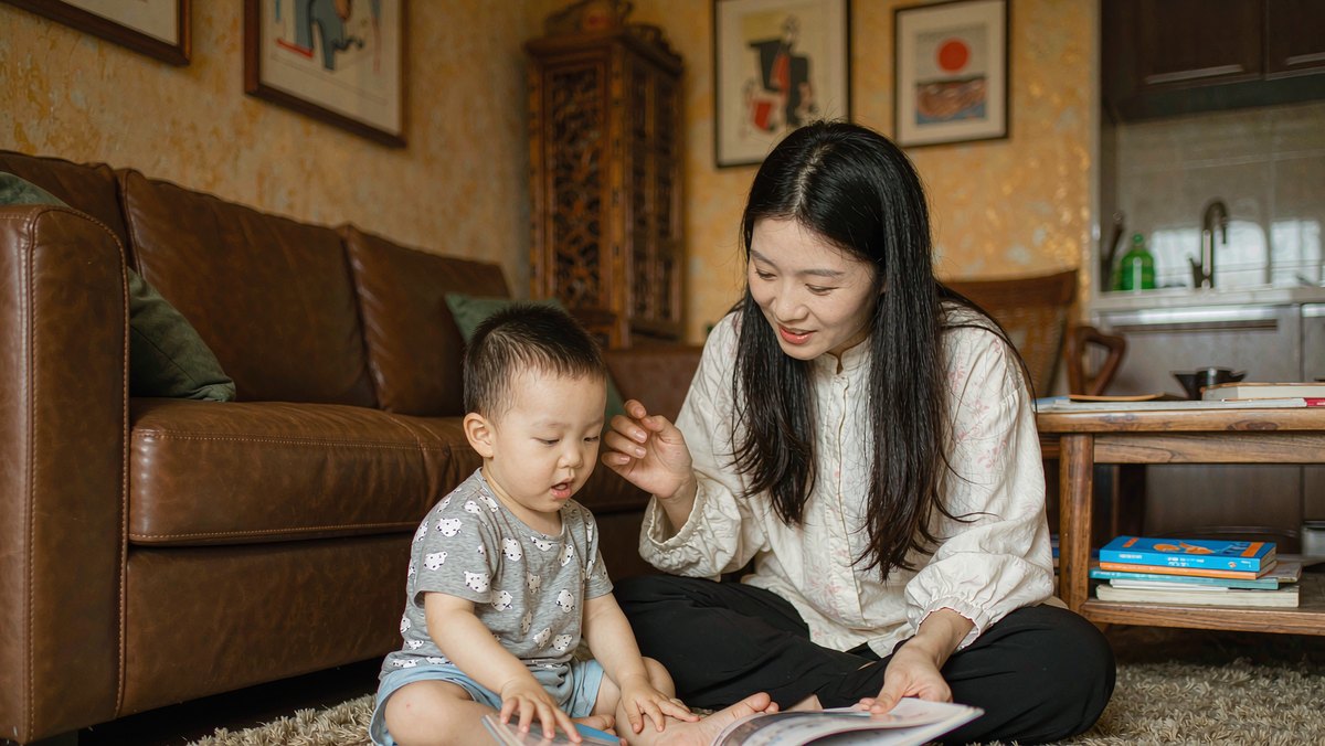 母子俩就绘本内容愉快地聊天的温馨场景