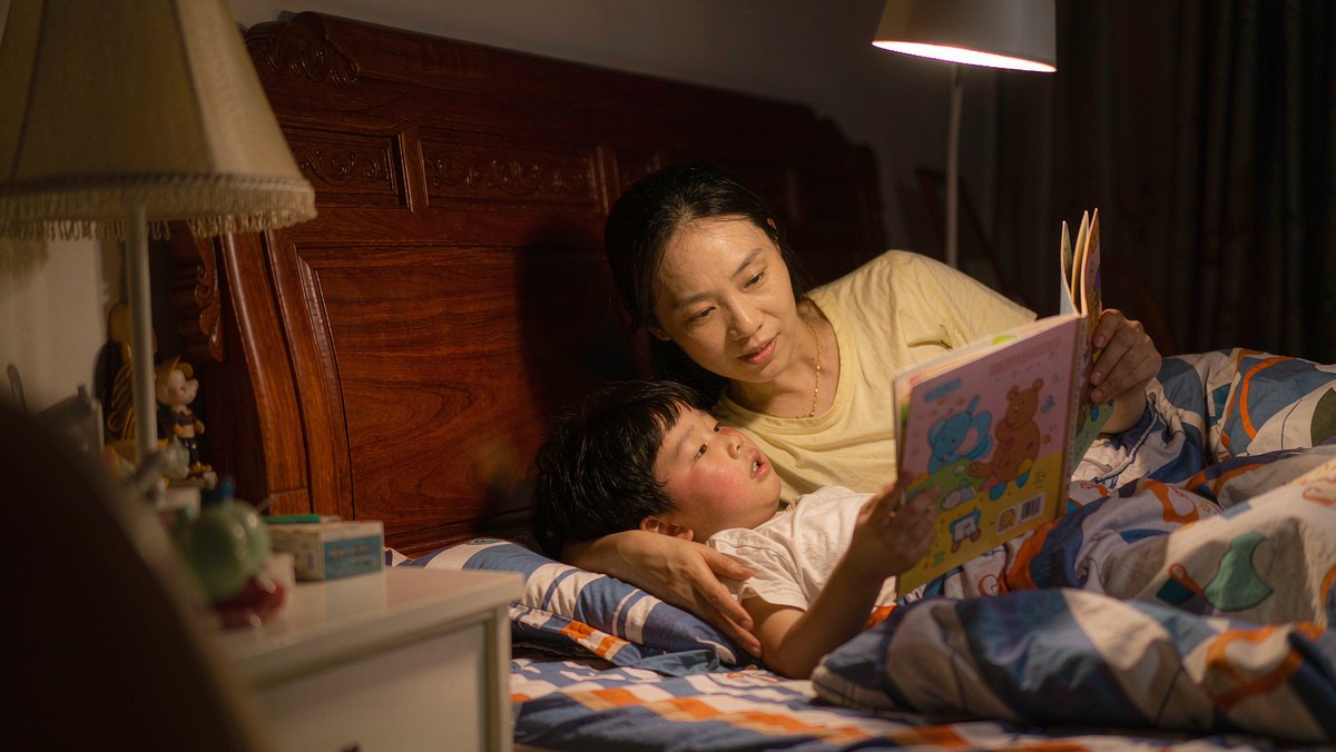 孩子生病卧床时妈妈在床边读绘本