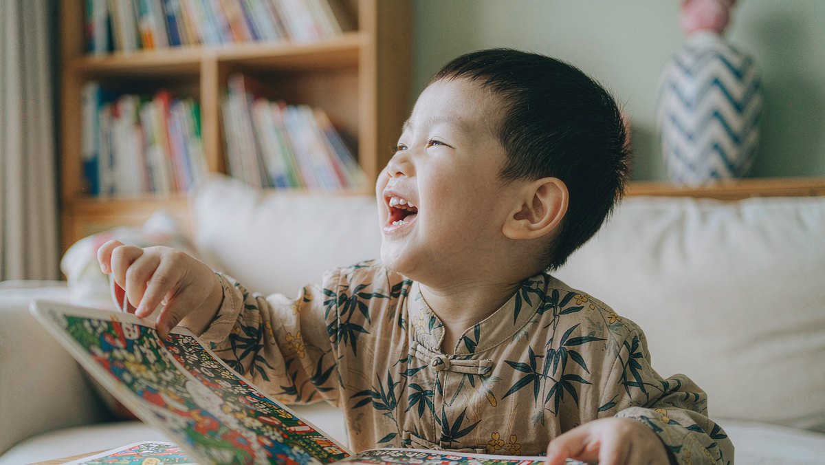 孩子笑着抢着翻绘本的下一页