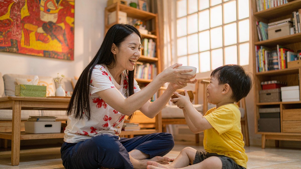 妈妈陪孩子用玩具碗筷演绘本情节