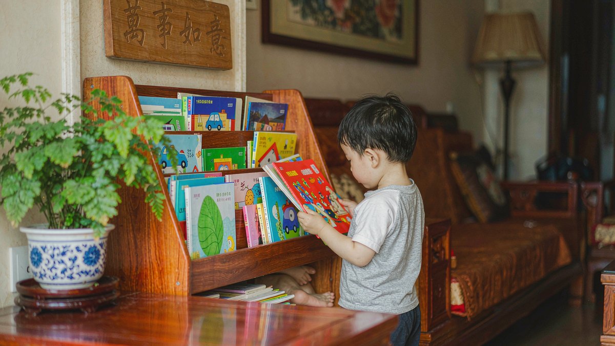 书架前孩子自己随手抽取绘本准备泛读