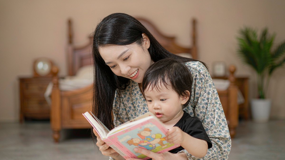 妈妈搂着孩子一起看绘本温柔交谈