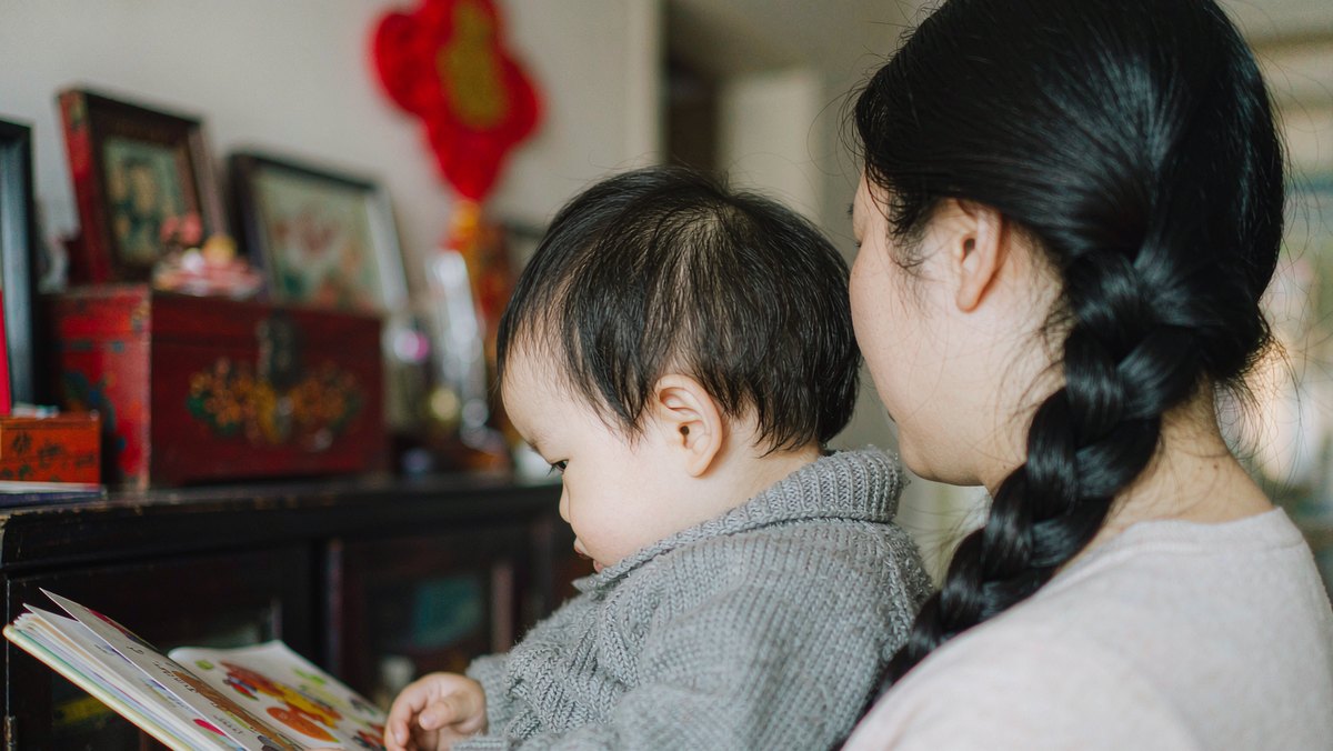 孩子安心靠在妈妈肩头一起读书
