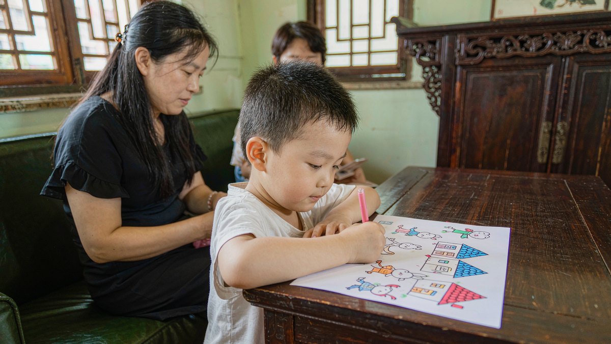 孩子把自编的故事画成小画开心展示